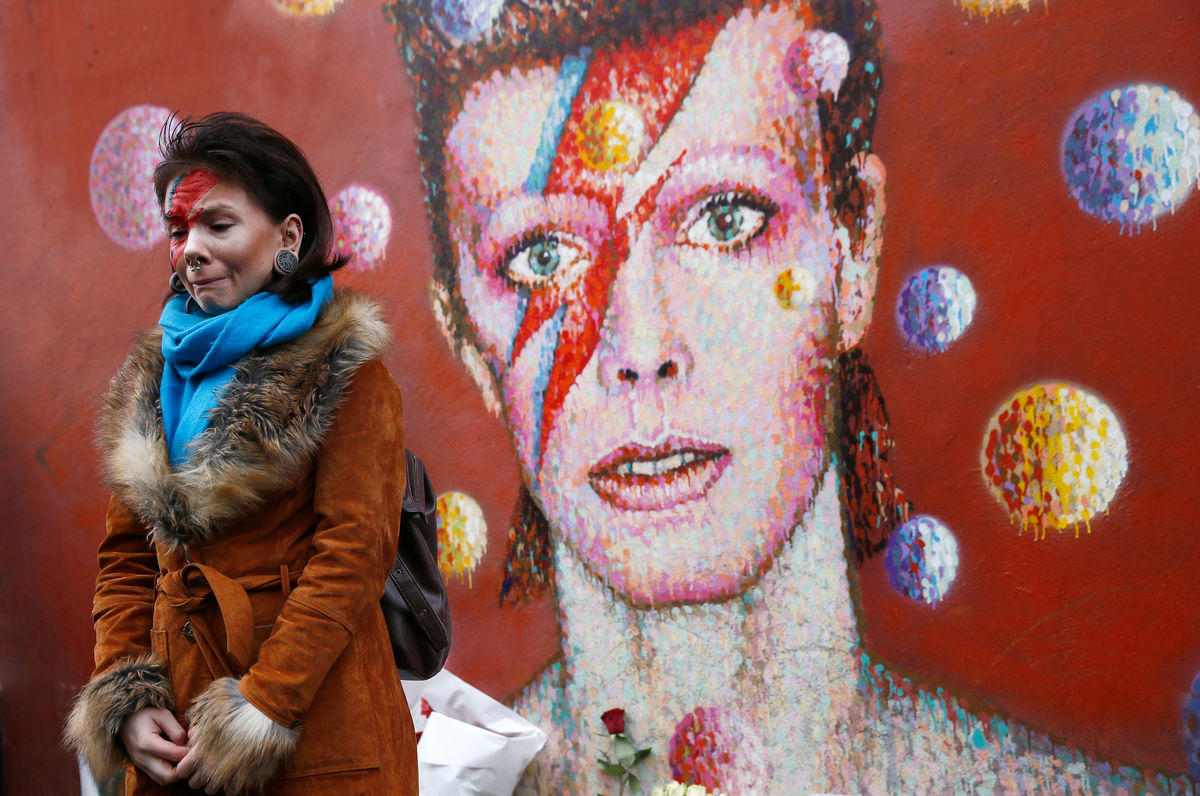 Uma mulher pintada ao estilo Ziggy Stardust chora em frente ao mural de homenagem a Bowie, em Brixton, sul de Londres (REUTERS/Stefan Wermuth)