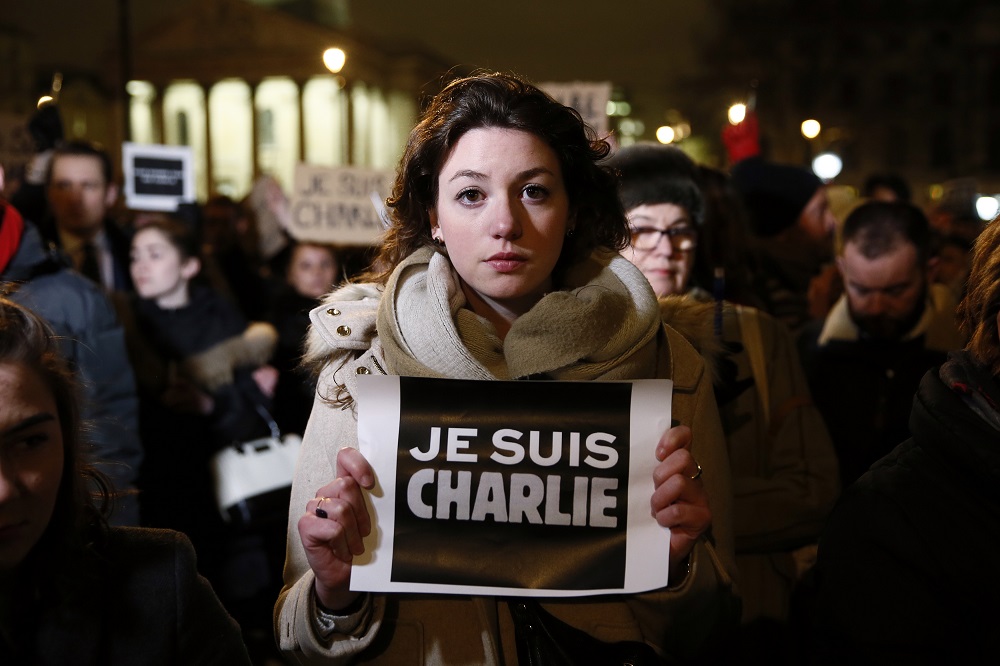 Woman holds a placard during a vigil to pay tribute to the victims of a shooting by gunmen at the offices of weekly satirical magazine Charlie Hebdo in Paris, at Trafalgar Square in London