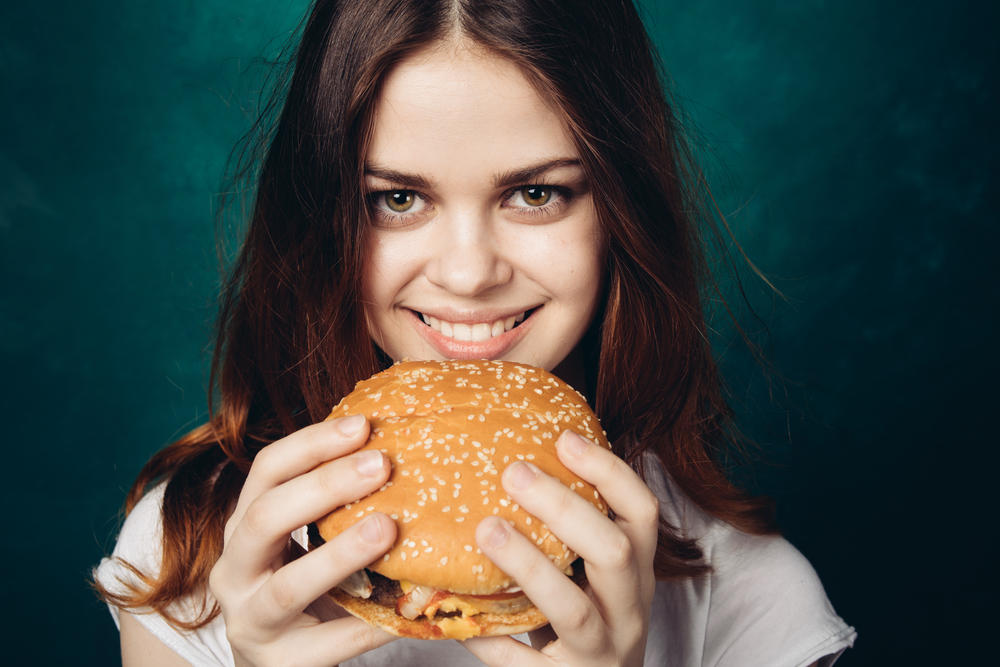 Mulher comer hamburguer