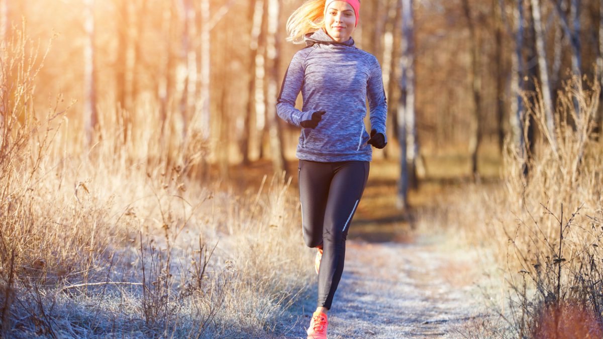 Young girl running in the park in early winter