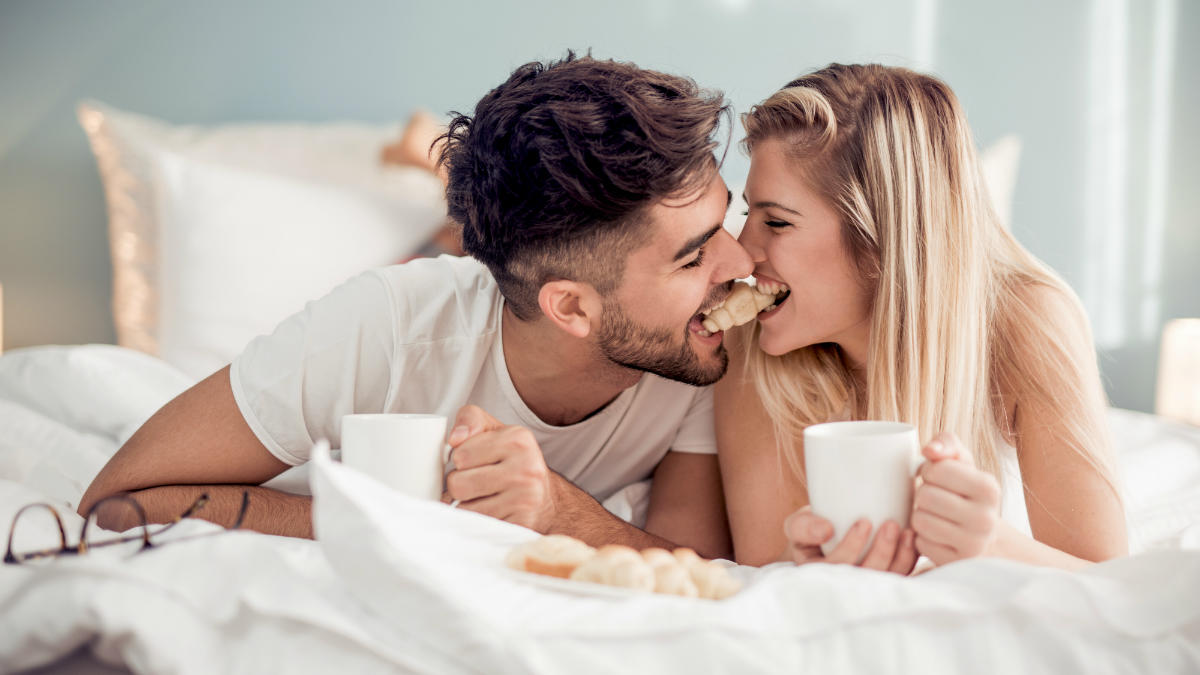 shutterstock_casal_comer_cama