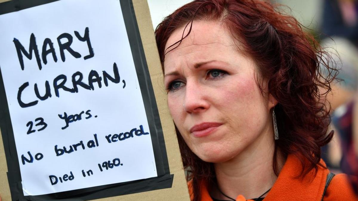 A woman attends a vigil at the site of the Tuam babies graveyard where the bodies of 796 babies where uncovered at a site of a former catholic home for unmarried mothers and their children in Tuam