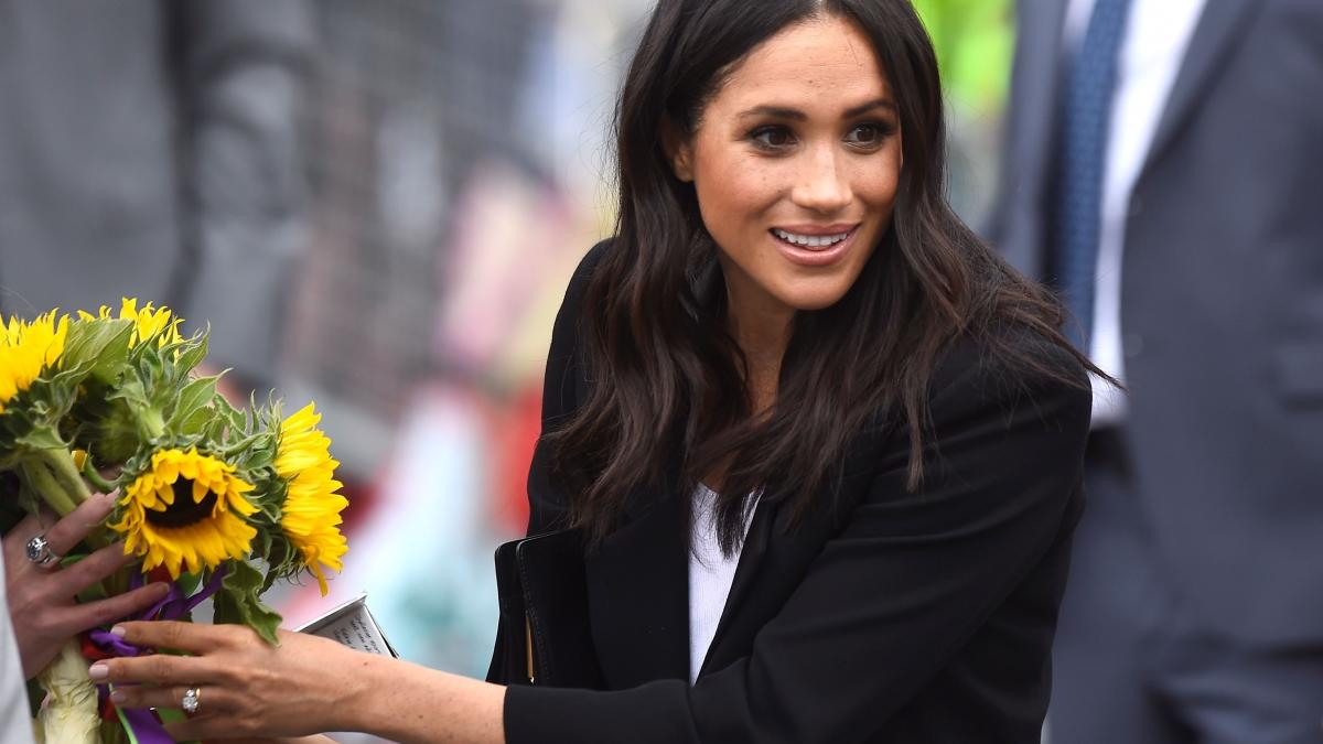 Britain’s Meghan, the Duchess of Sussex, accepts some flowers during a visit to Parliament Square in Trinity College, Dublin