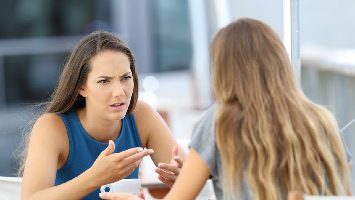 Two girls talking seriously in a coffee shop