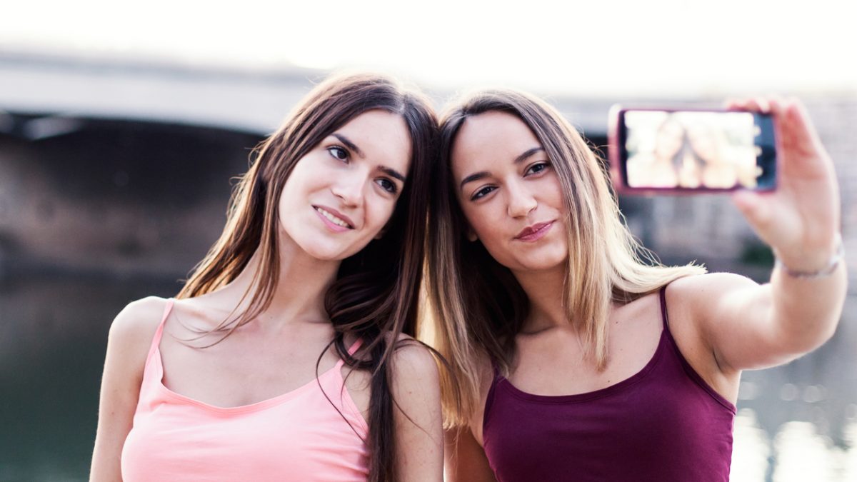 Happy friends taking selfie and laughing.