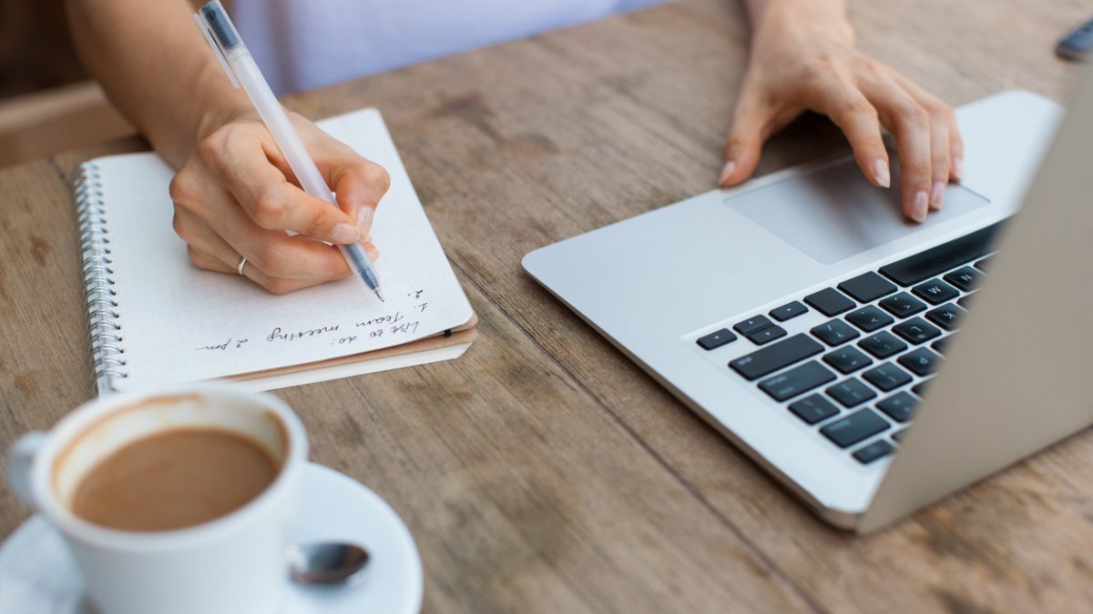 Cropped View of Woman Working on Laptop in Cafe