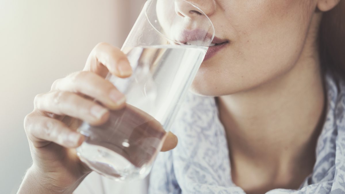 Young woman drinking pure glass of water