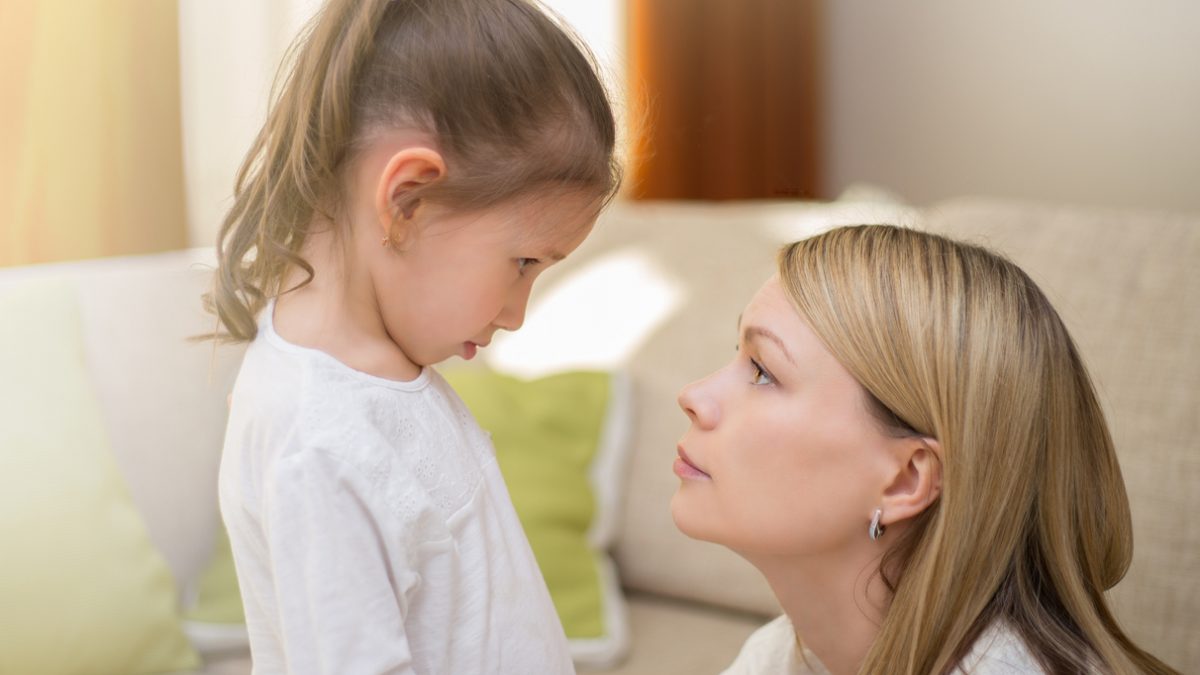 Beautiful mother is comforting her sad little daughter at home.