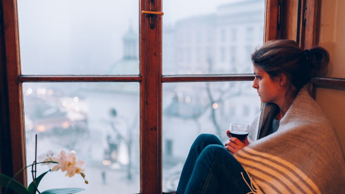 Depressed woman sitting near the window