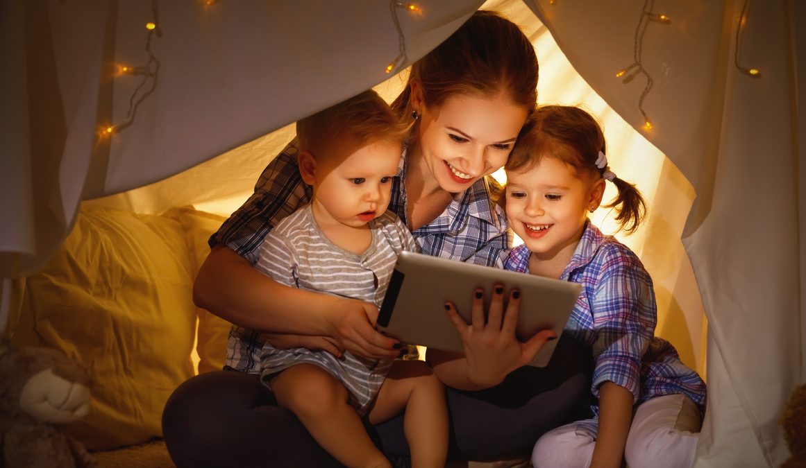 Happy family mother and children playing in tablet  pc