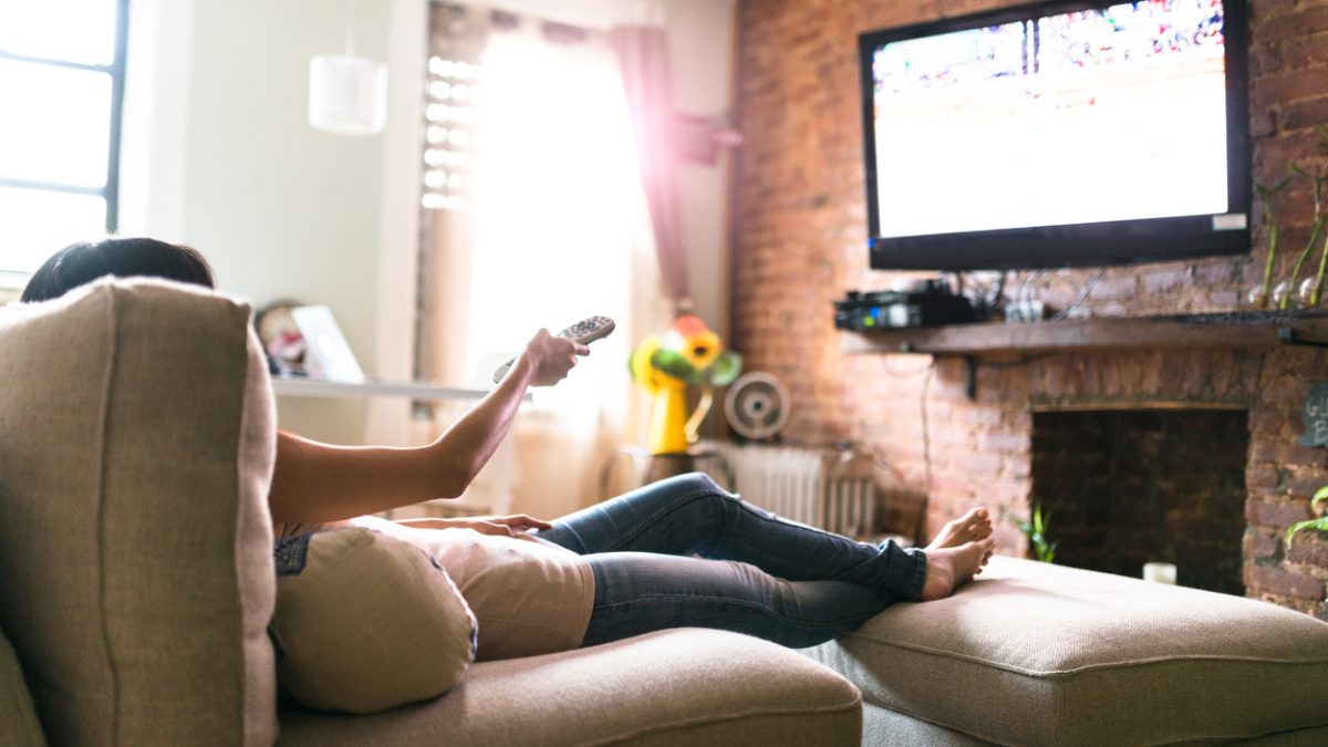 woman relaxing online on sofa reading some papers