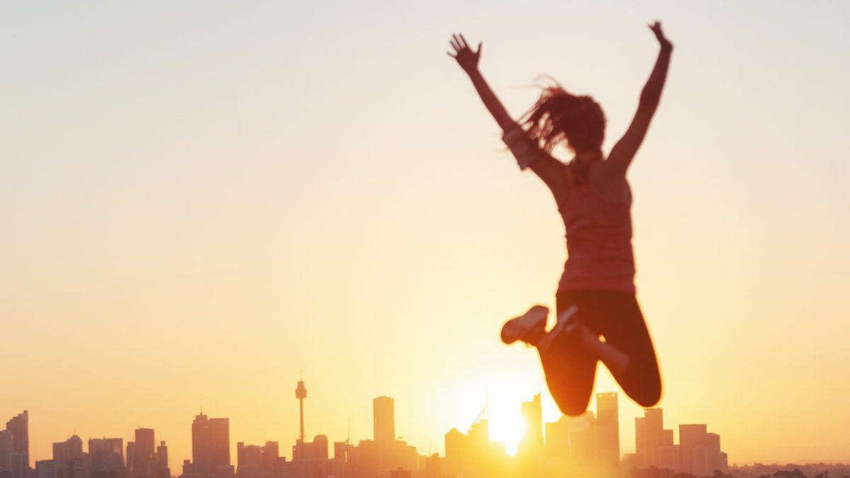 Sport women jumping and celebrating with arms raised.
