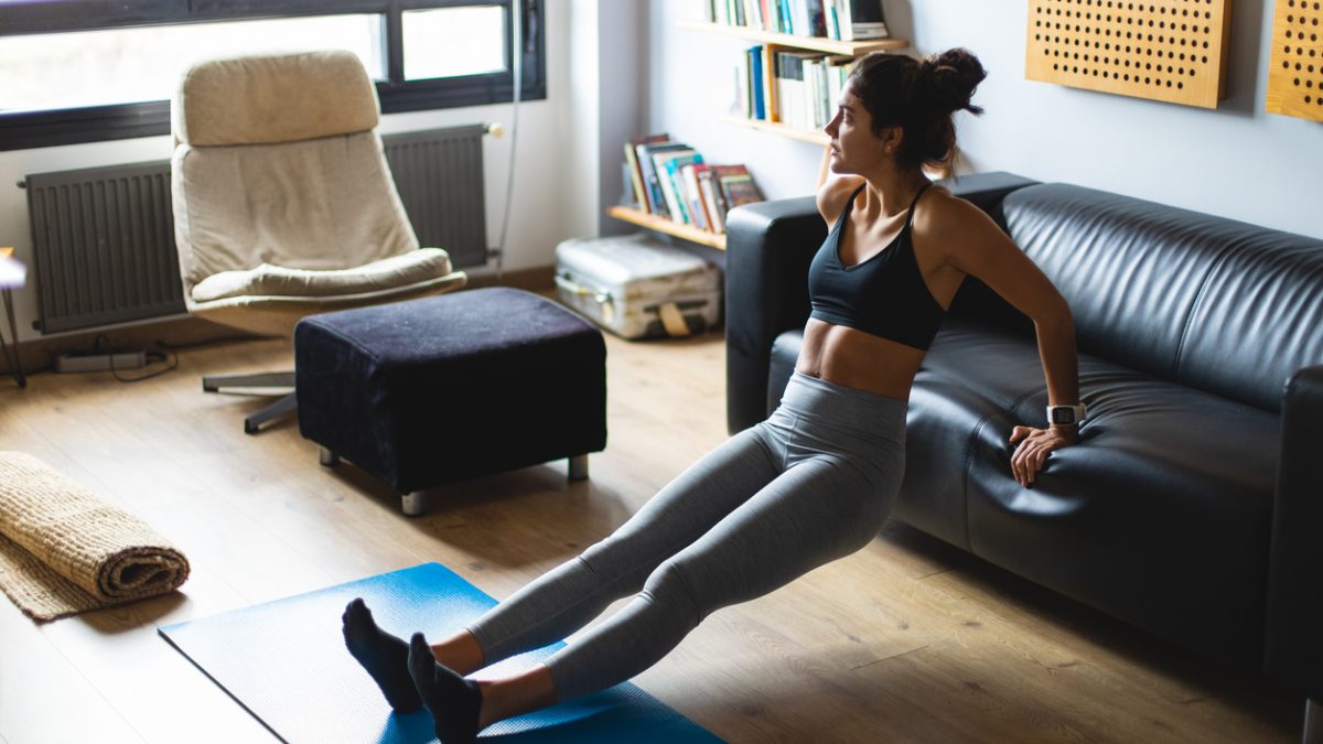 Young fit woman exercising at home