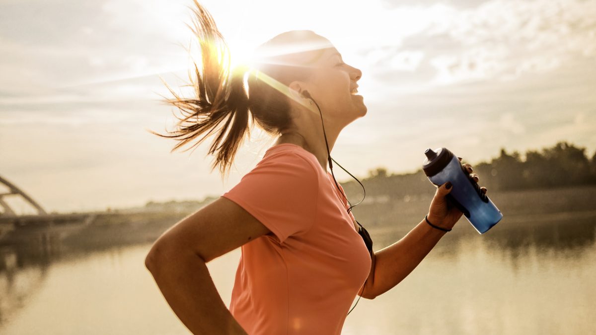Young woman running against morning sun